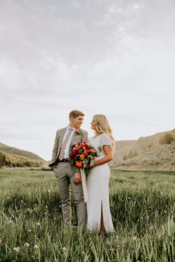bride and groom hugging in utah valley mountains taking pictures with their perfect wedding photographer