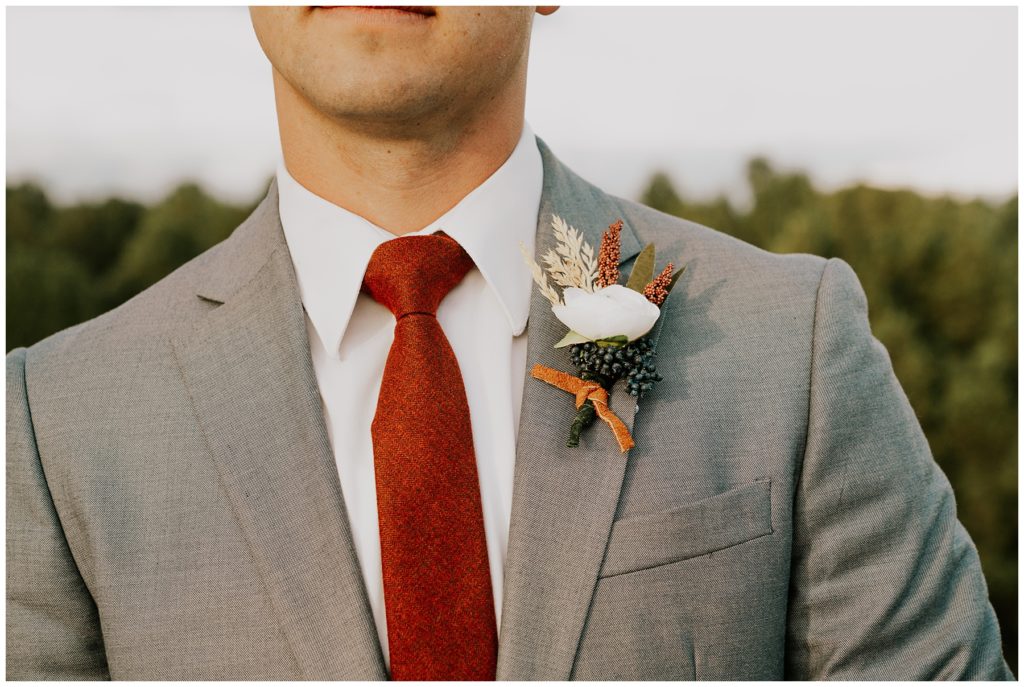 groom detail shot burgundy tie with fun floral 