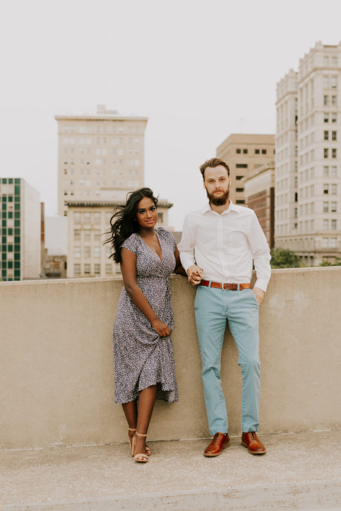man and wife standing together during engagement session in omaha