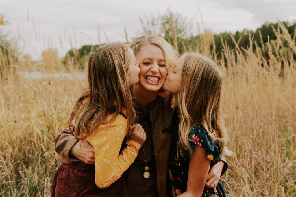 daughters kissing mother 