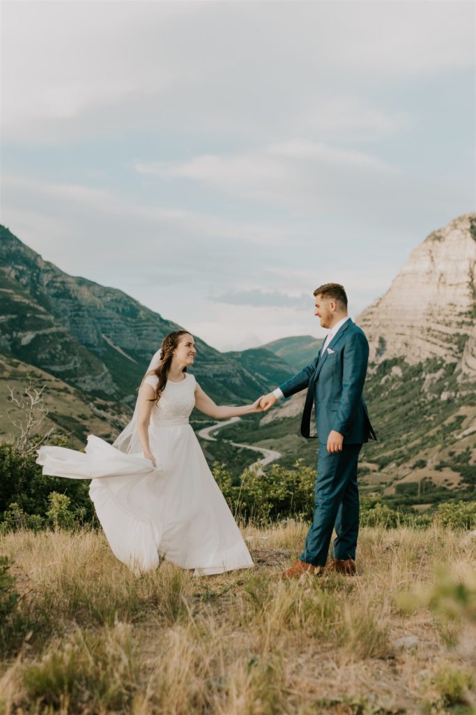 bride and groom posing on utah mountain during anniversary session