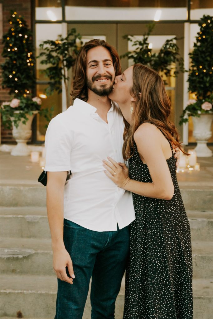 woman kissing man on cheek after recent proposal