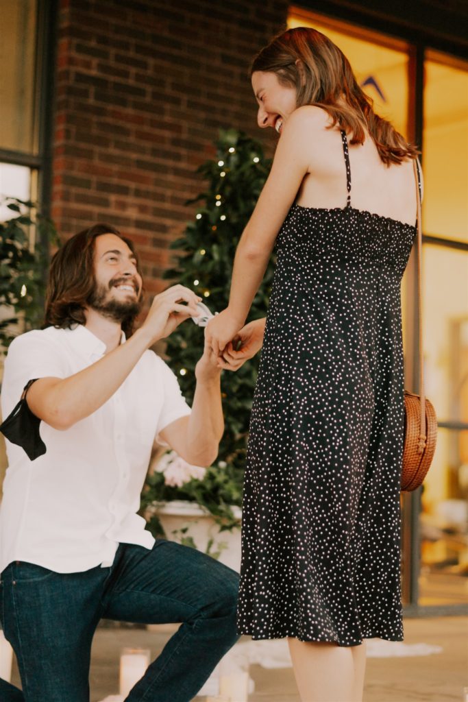 man on one knee proposing to woman during downtown omaha engagements