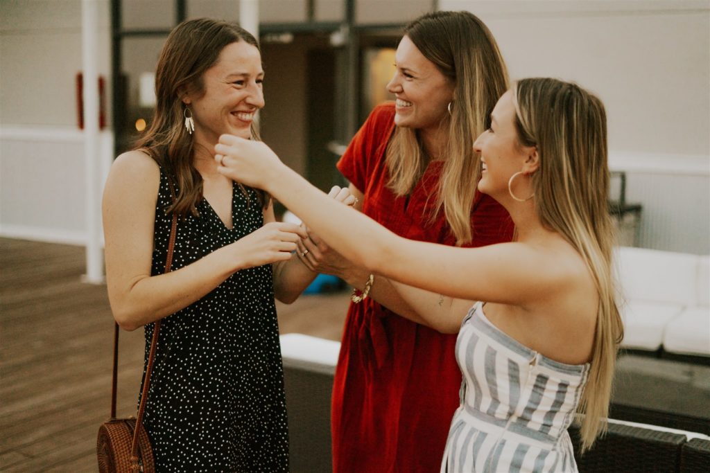 newly engaged woman celebrating with friends on rooftop proposal party