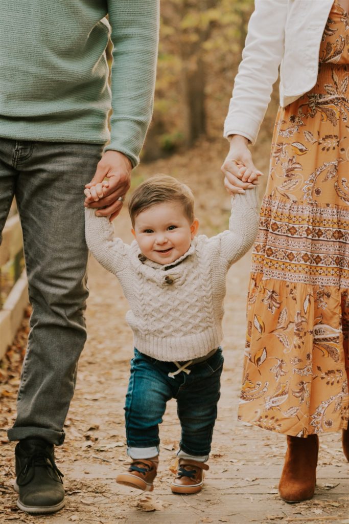 parents holding baby's hands during lifestyle shoot