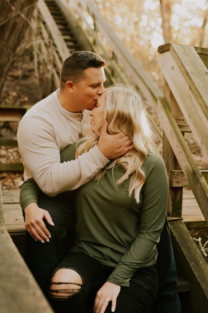 man kissing woman's forehead during engagement session in Gretna NE