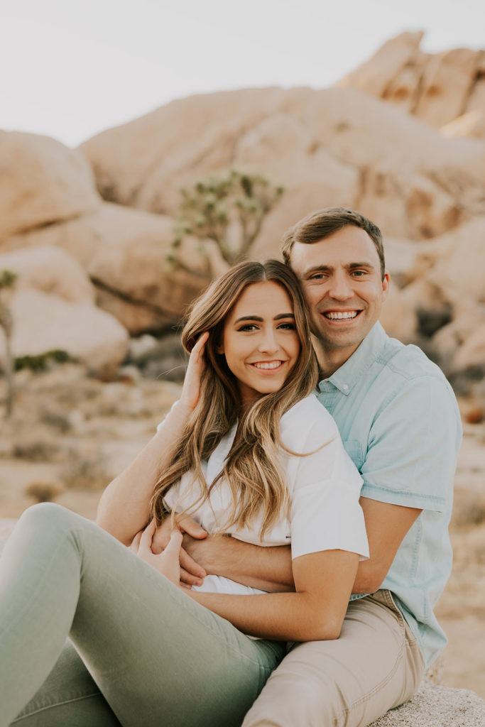 Man and woman sitting together and cuddling during Joshua tree couple session