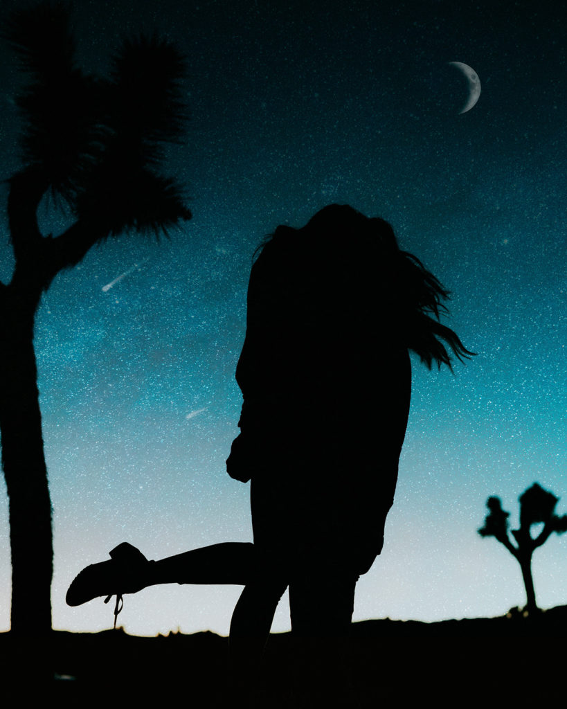 Man and woman hugging and spinning while star gazing at night 