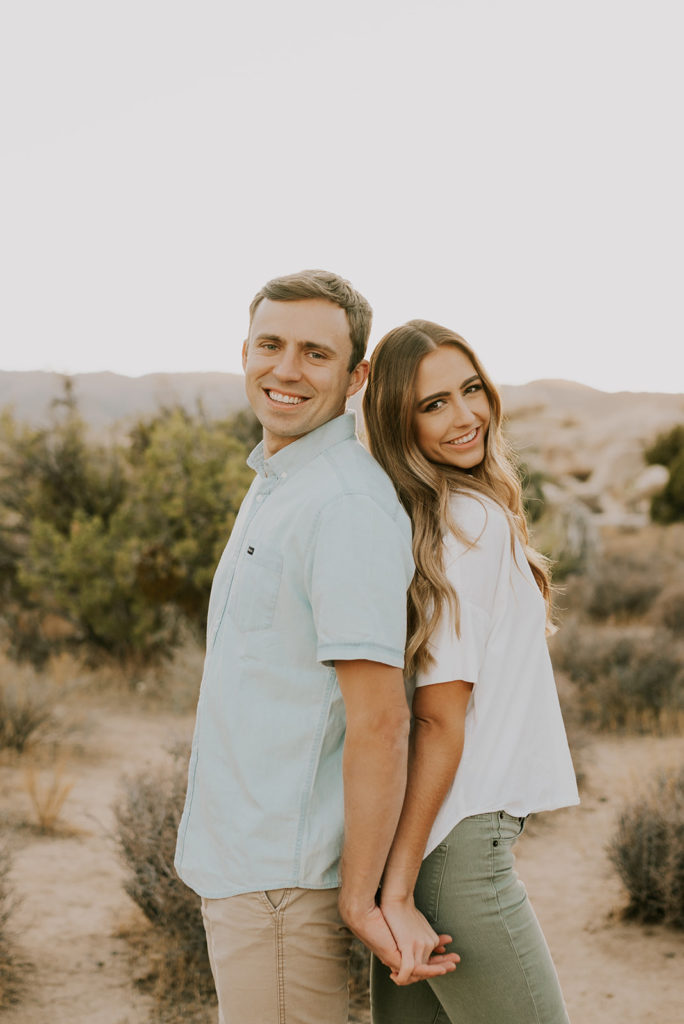 Man and woman standing back to back in Joshua Tree couple session