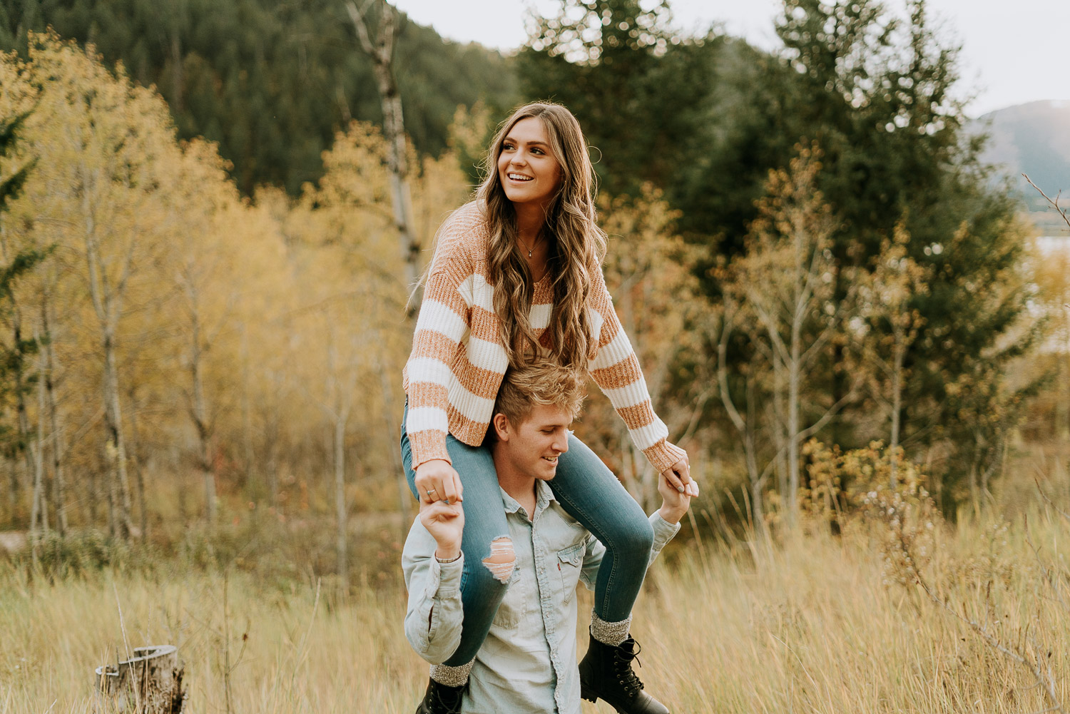man and woman playing in idaho field during engagement session