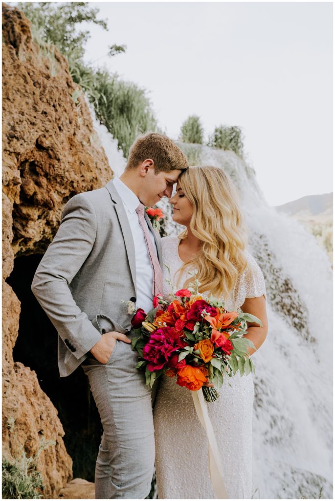 bride and groom posing by waterfall during bridals adventure session