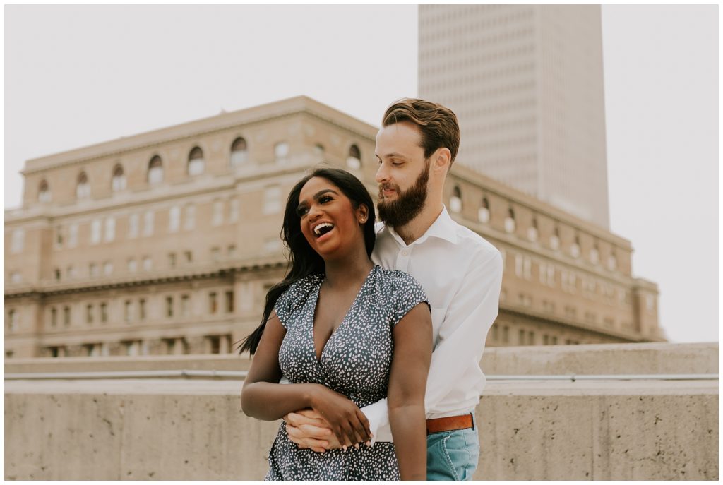 couple hugging on top of omaha building during engagement session