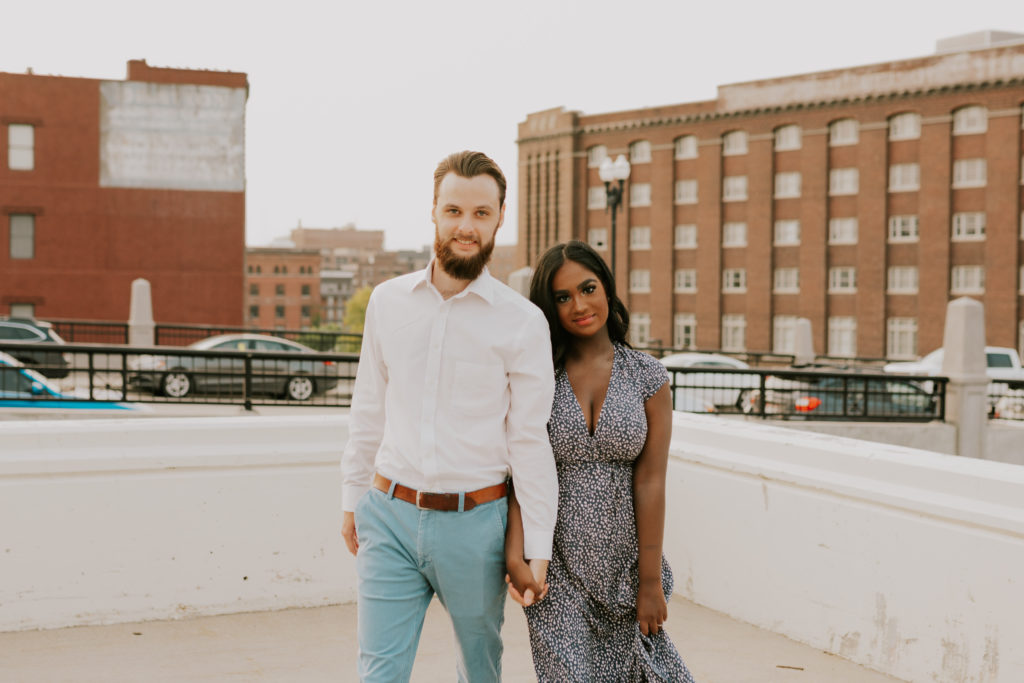 man and woman posing on omaha building during engagement session