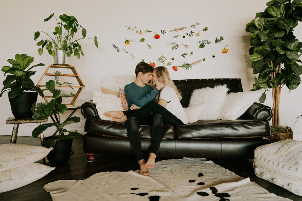 couple posing on couch during couples session in home cozy session