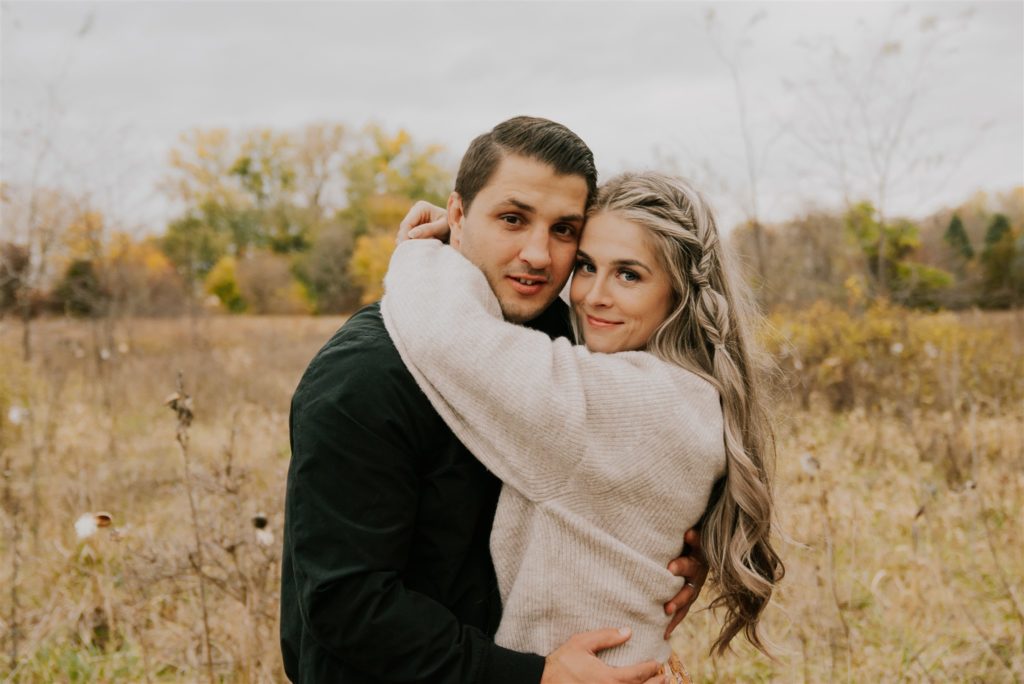 man and woman posing in omaha field in fall shoot