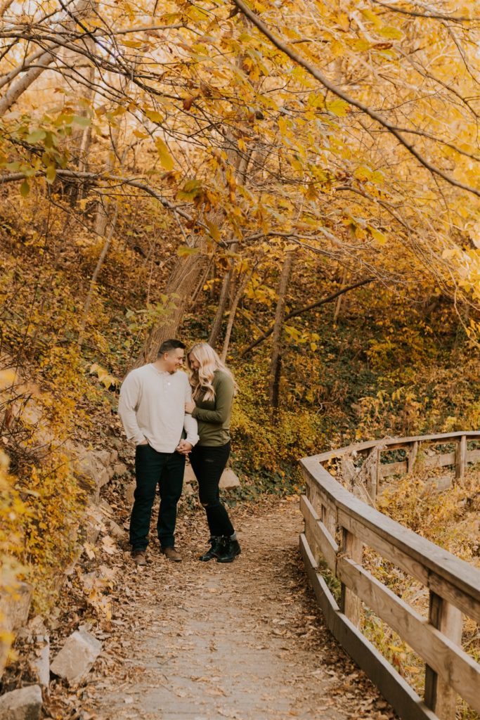 man and woman posing on nebraska bridge in Gretna fall engagement session
