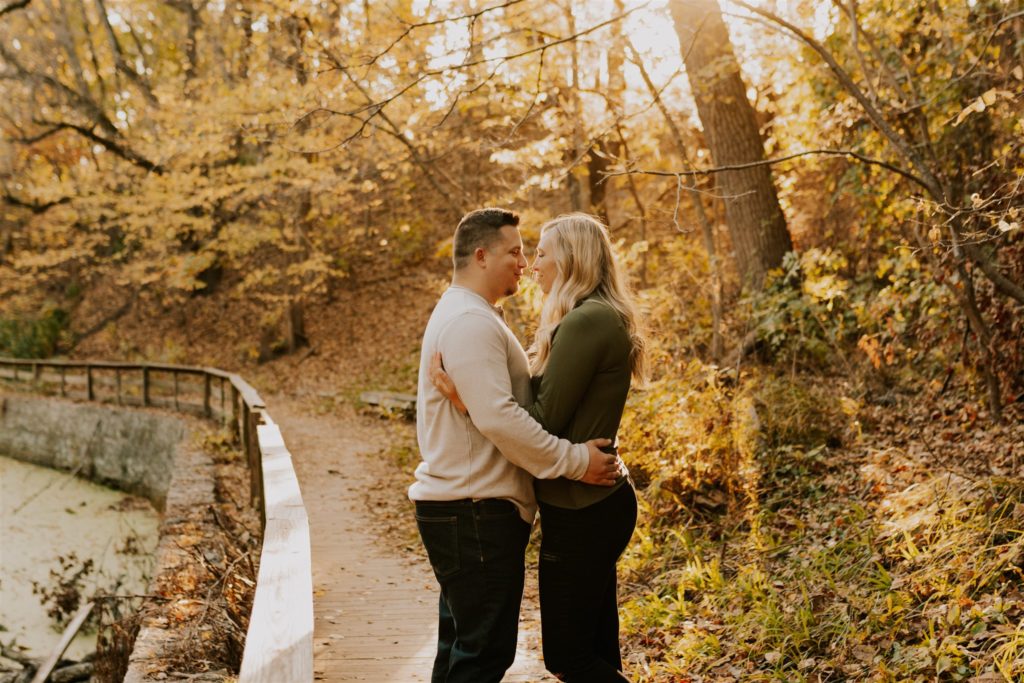 man and woman posing in omaha field during fall couples session