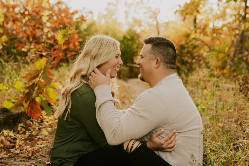 man holding woman's face and hugging in outdoor gretna fall engagement session