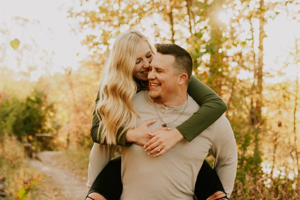Man carrying woman on back during Omaha engagement session