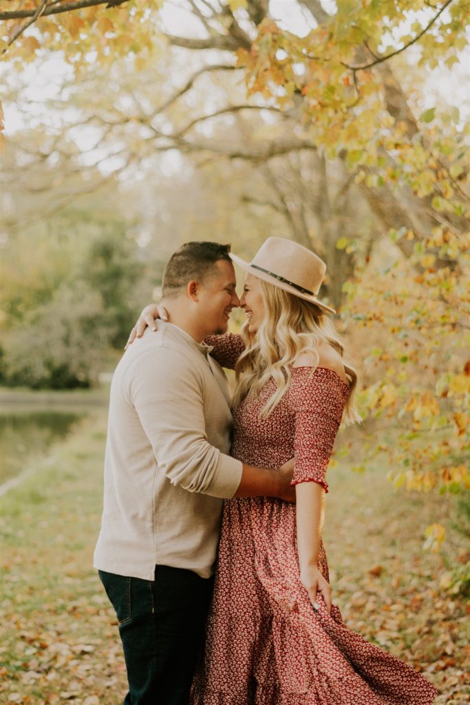 man and woman kissing and smiling in Gretna fall engagement session
