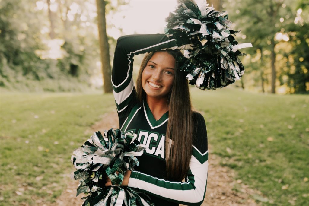 young woman posing in cheer uniform during outdoor forest fun