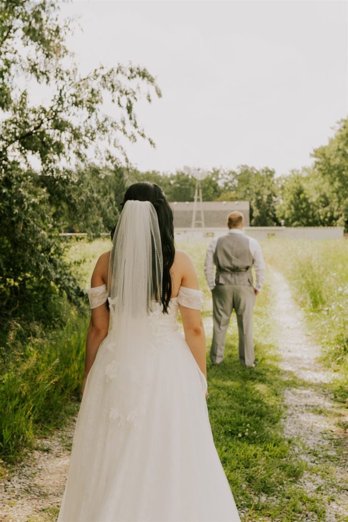 bride walking over to see groom during first look at backyard wedding in nebraska