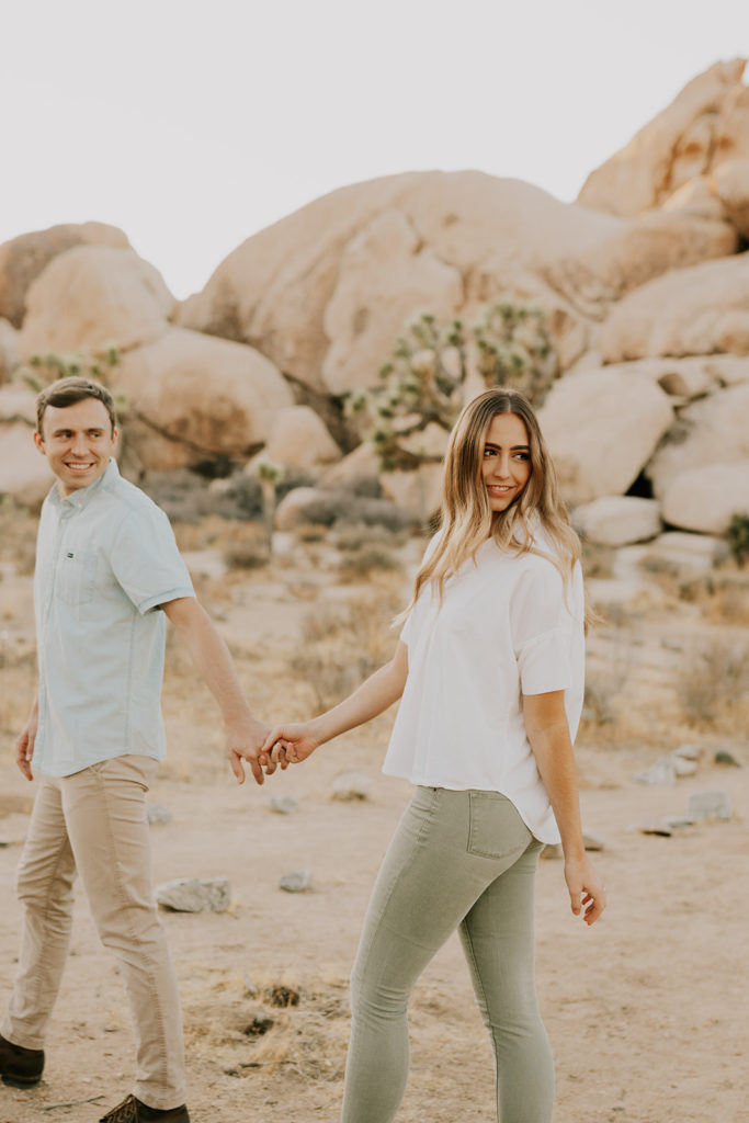 Husband and wife holding hands in Joshua tree